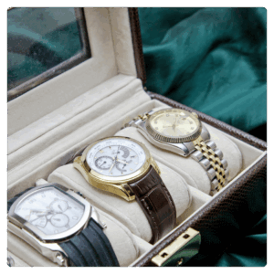 Luxury wristwatch collection in a leather display case, featuring gold and silver chronograph watches with leather and metal straps — premium men’s timepieces for elegant style